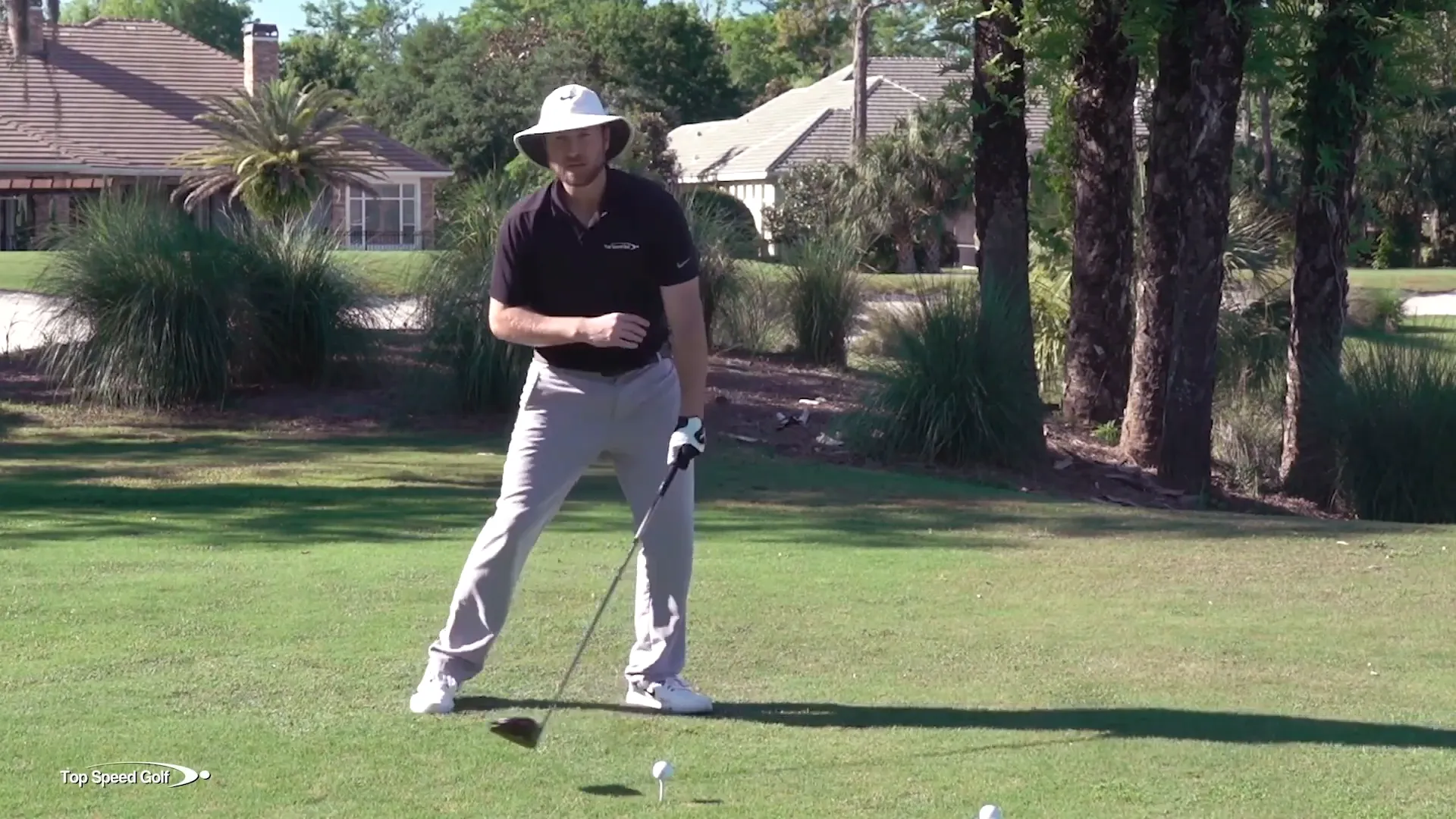Demonstrating the open body position in a swing