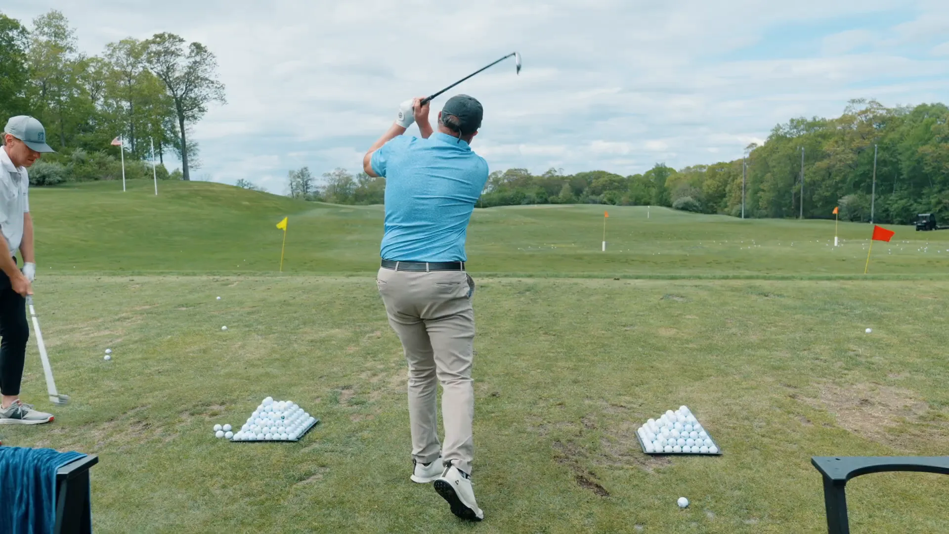Golfer practicing backswing with a pause at the top to improve rhythm and position