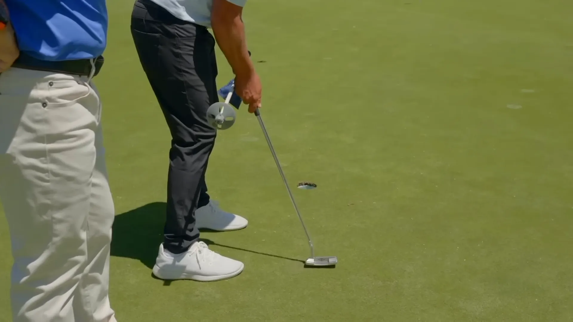 Demonstration of hands traveling straight back while the putter head naturally arcs