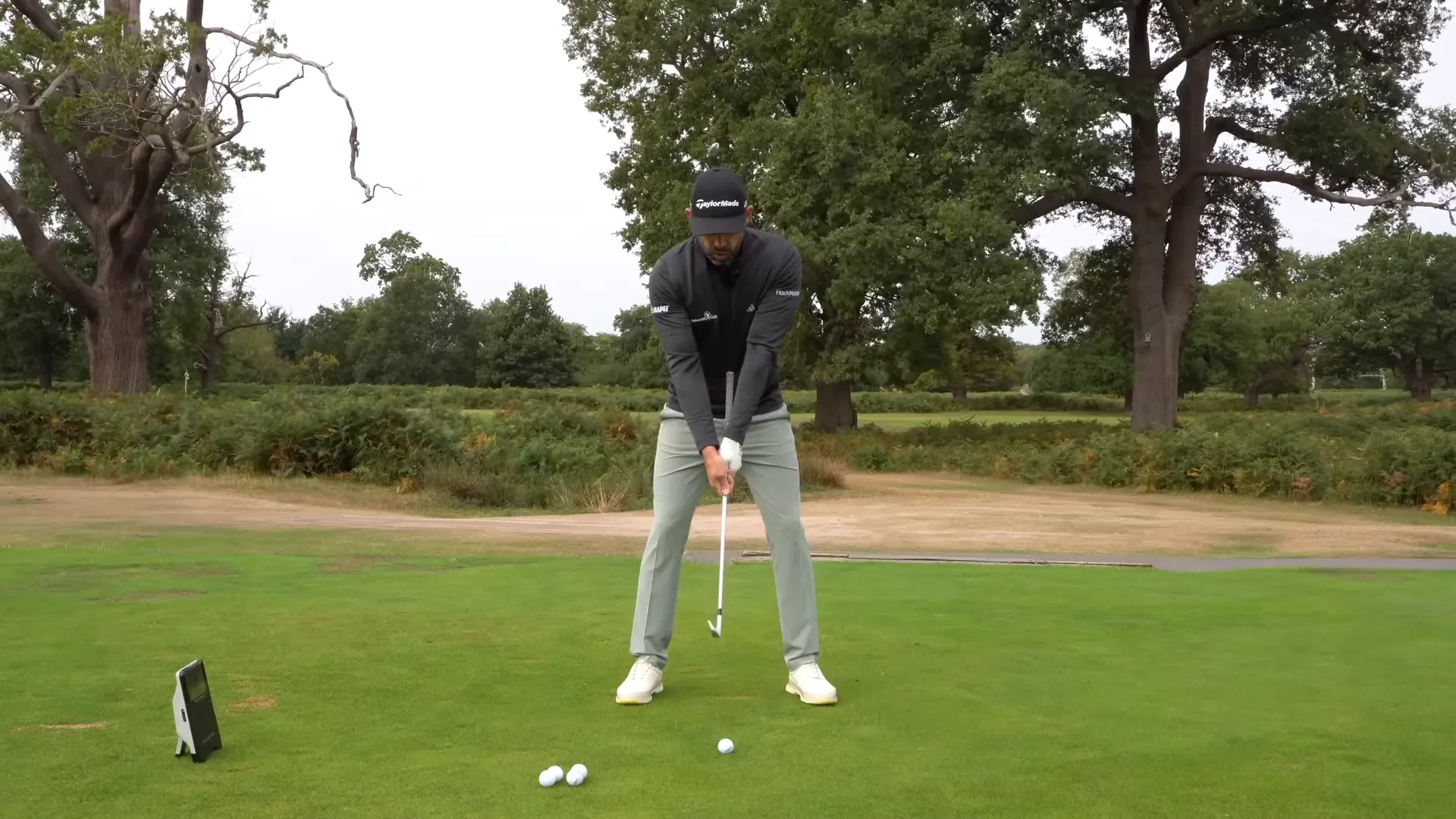 Coach demonstrating the belly-button club drill with hands on shaft