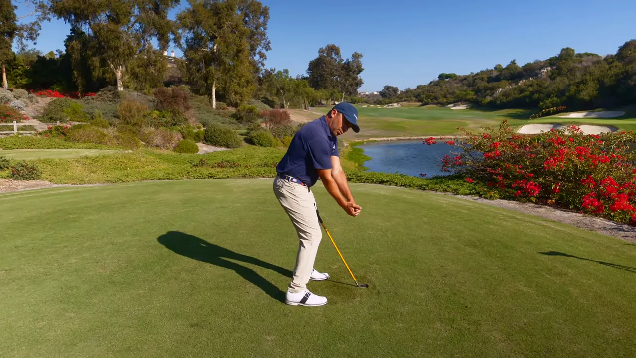 Player on the range using alignment rod to check takeaway path