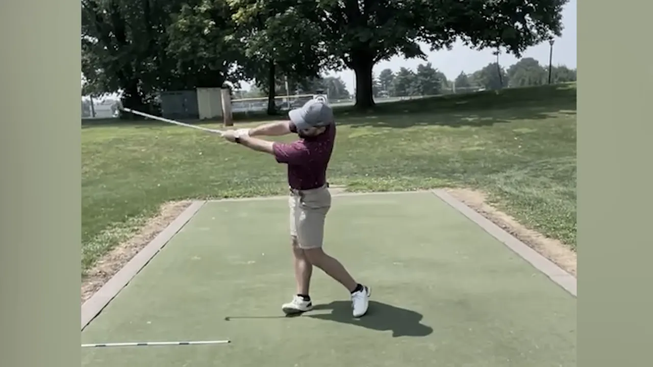 Golfer pushing arms away and achieving a long arc in the follow through