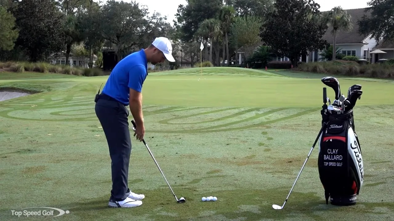 Golfer setting up a chip shot with ball slightly back of center, showing stance and club position