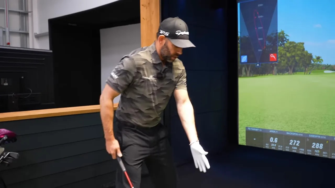 Instructor in indoor simulator extending his glove hand with open palm to demonstrate hand rotation