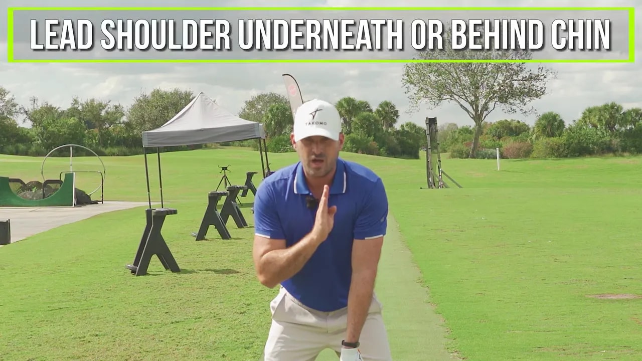 Instructor demonstrating left shoulder under or behind the chin with hand near face