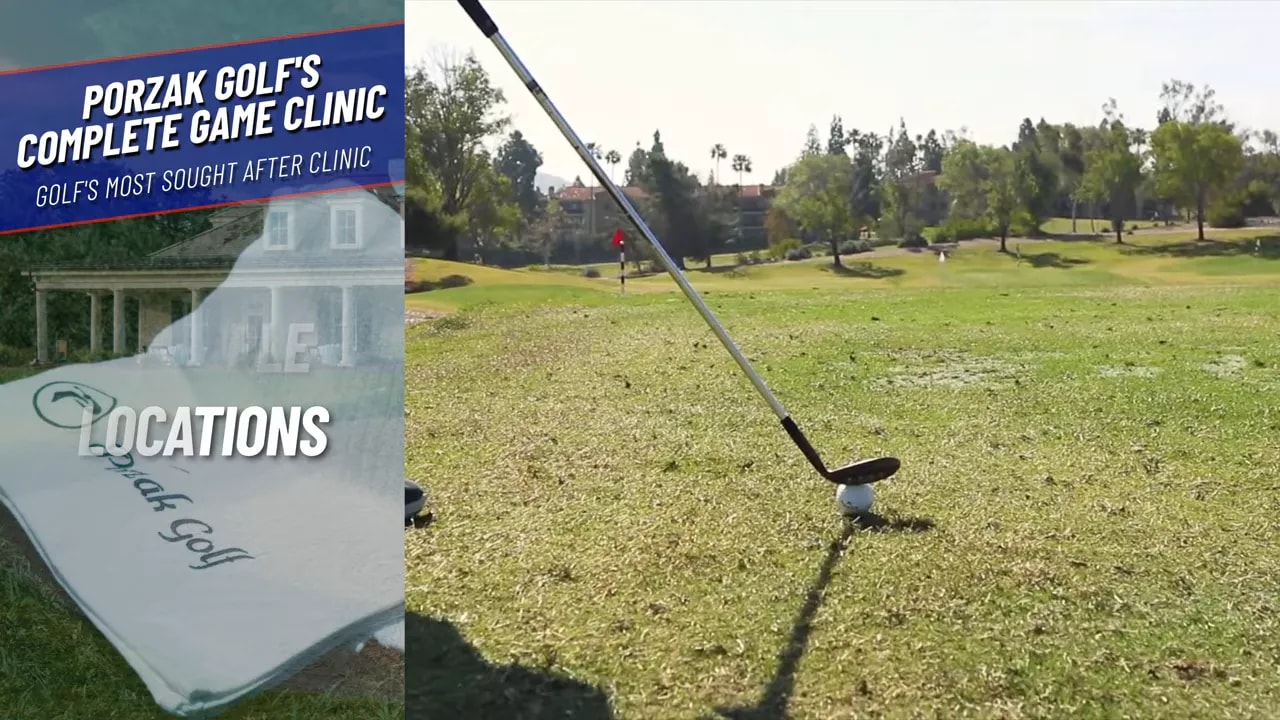 Wedge clubhead behind the ball with the shaft leaning forward on the turf, illustrating correct setup for a wedge shot.