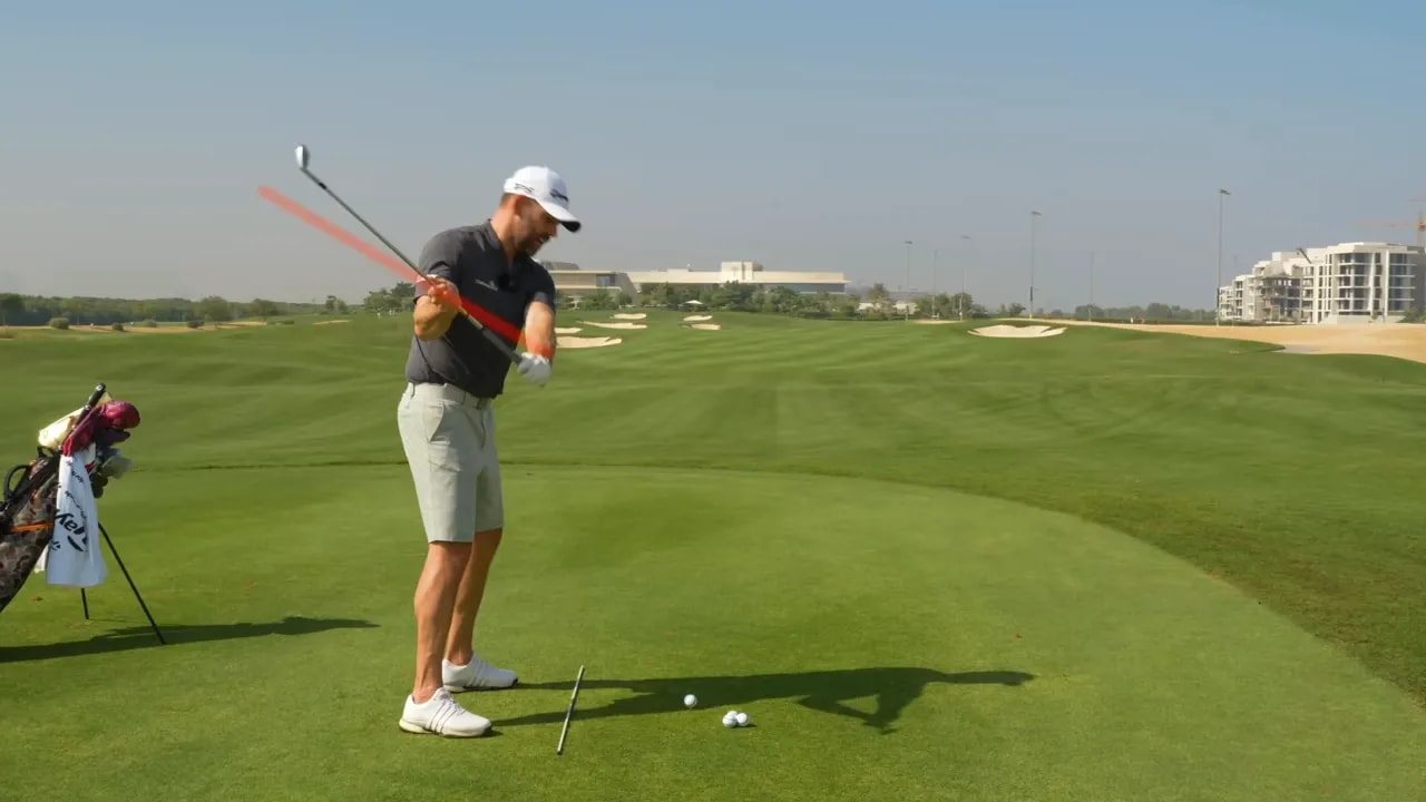 Golfer demonstrating wrong shallowing with a flattened shaft highlighted in red and elevated hands over the ball.