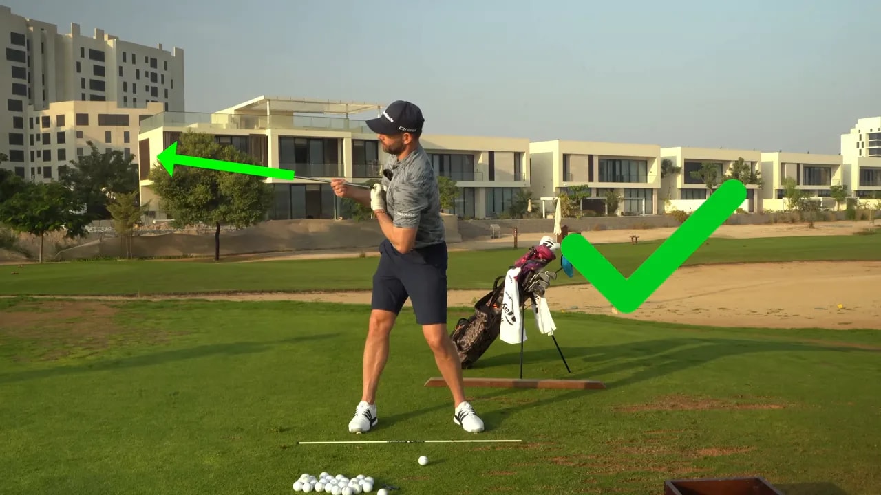 Golfer at mid-backswing showing a rotated chest lifted up and back; green arrow and checkmark overlay highlighting correct movement.