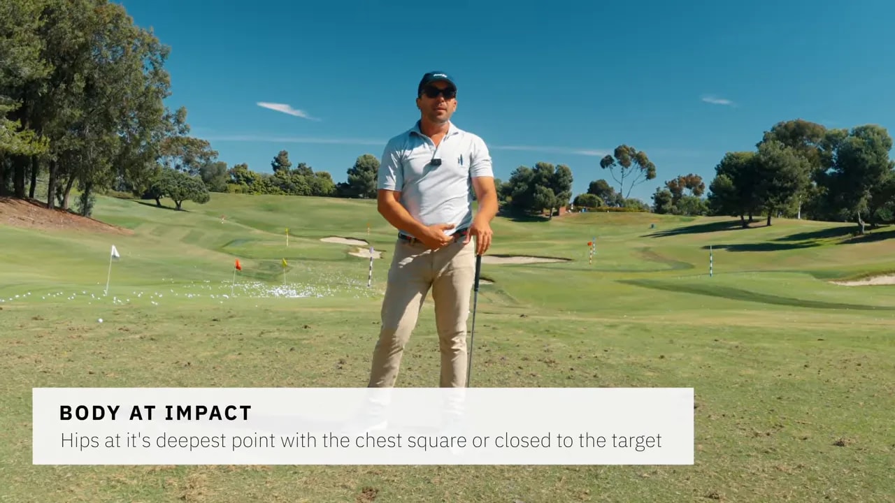 Golf instructor on the range showing body position at impact with hips deepest and chest square or closed to target