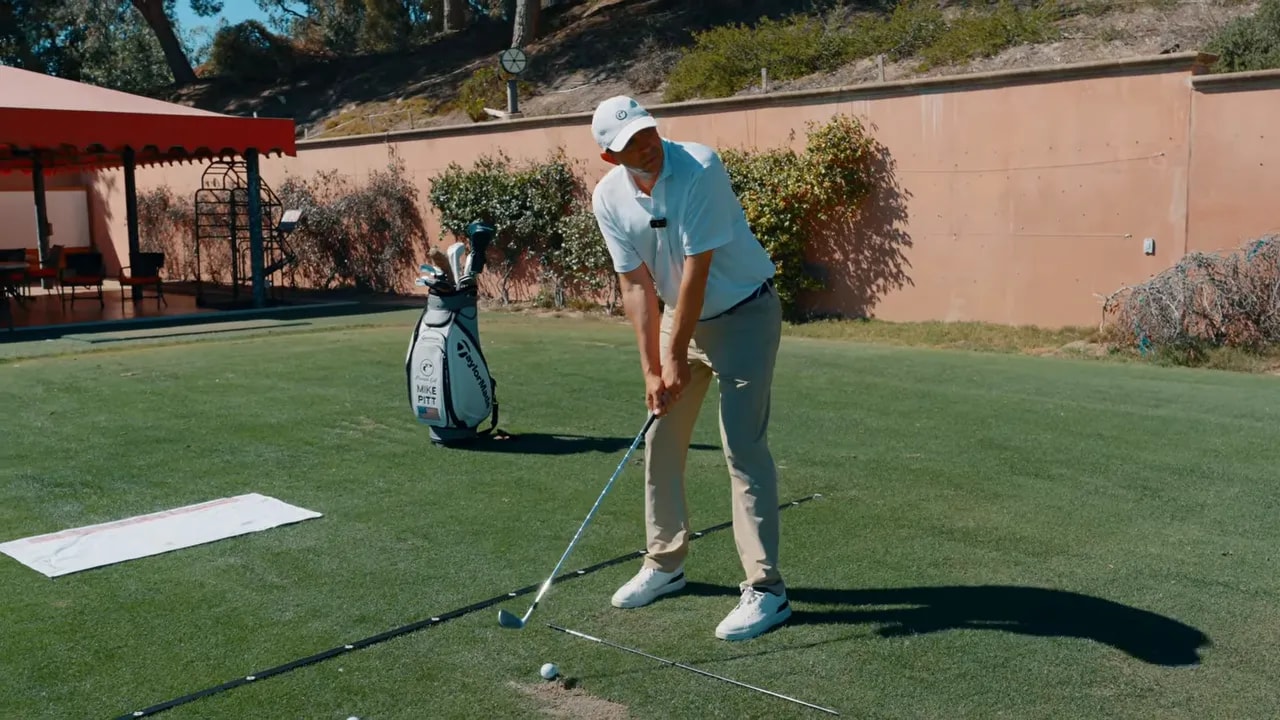 Golf instructor demonstrating a consistent pre-shot routine setup on a practice green