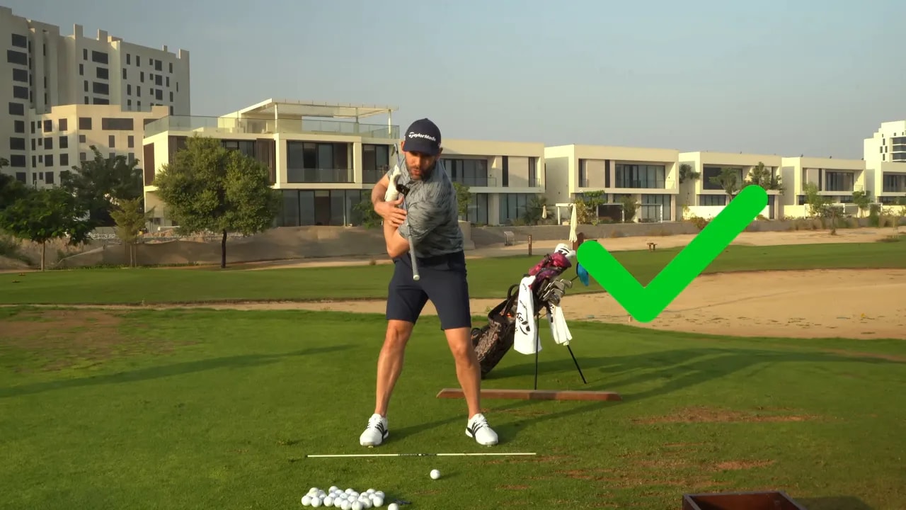 Golfer demonstrating a correct backswing with chest up and back and a green check overlay