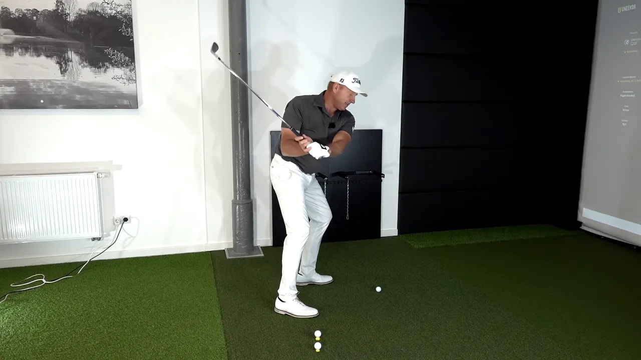 Golfer showing club position during downswing with controlled wrist flex to shallow the path
