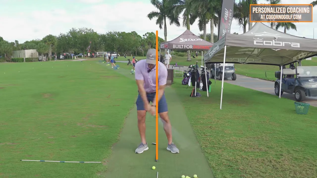 Golfer mid-swing during drill with forward body position emphasizing turf-first contact