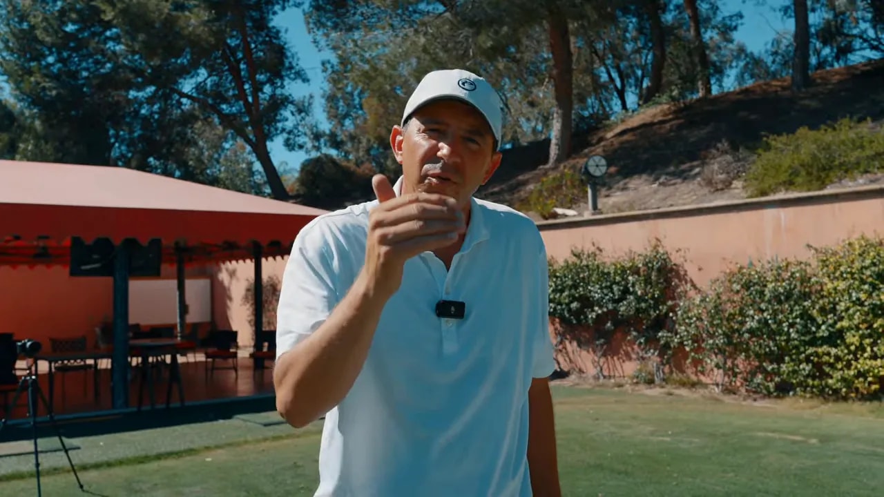 Golf instructor explaining a repeatable pre-shot routine on the range