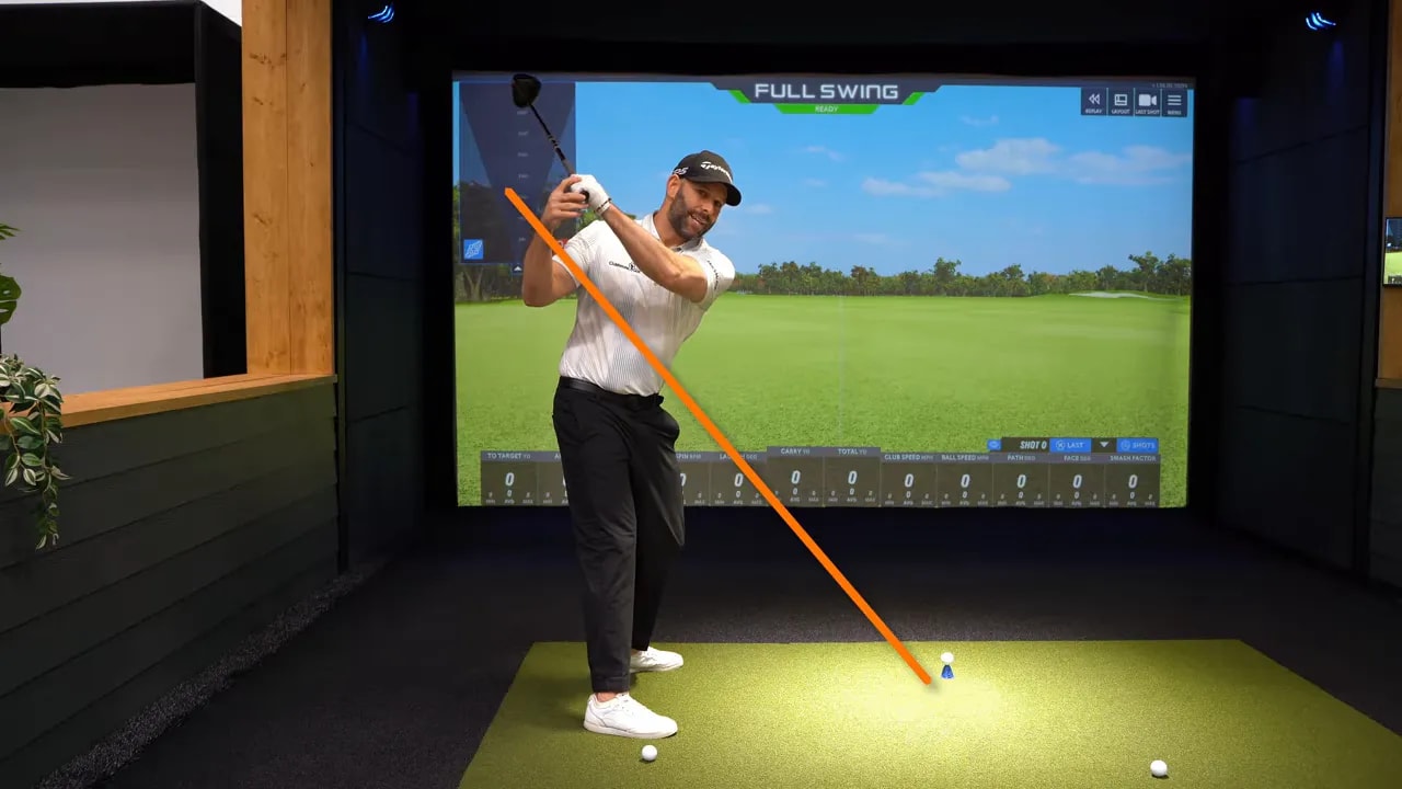 Golfer demonstrating the 5 o’clock drill with orange line marking the in-to-out transition feel reference