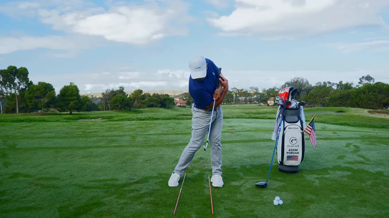 Golfer demonstrating hip bump body position near impact on the practice fairway