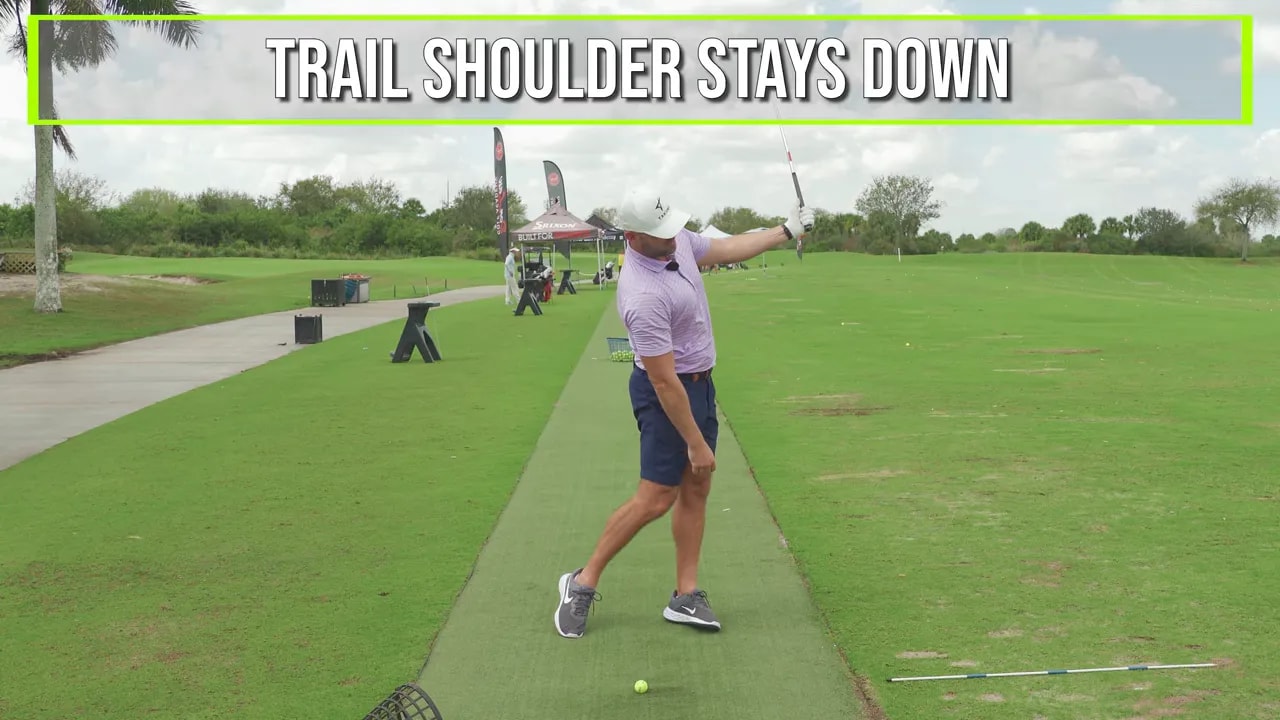 Golfer showing correct follow-through intention: lead arm down and left during golf swing