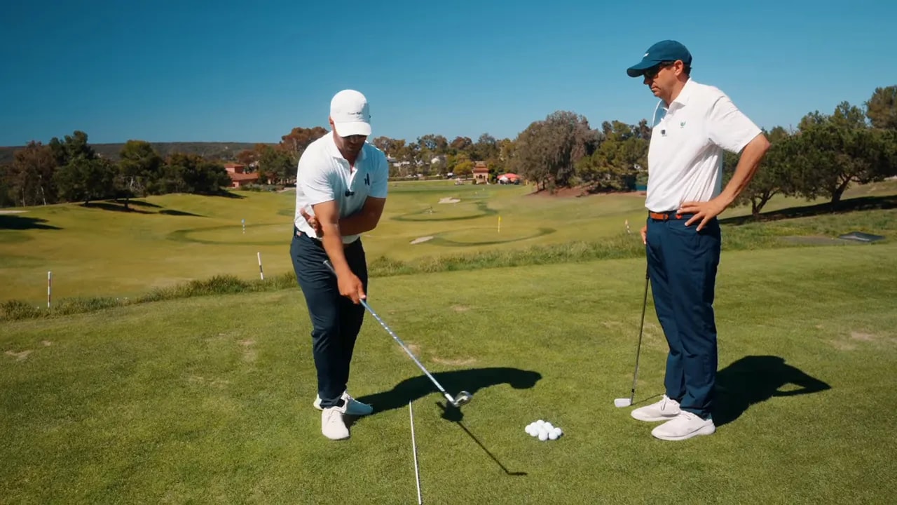 Golfer demonstrating the lead-hand-behind-trail-elbow drill to keep the trail elbow in front of the torso