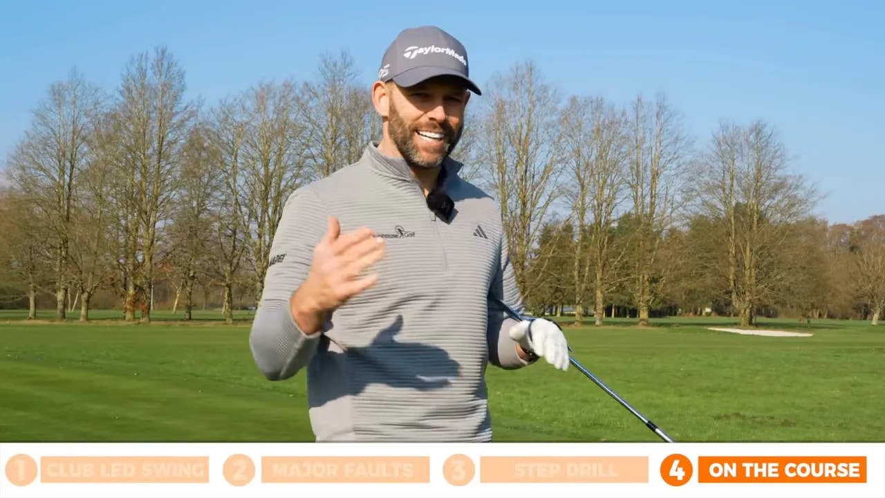 Golfer explaining not freezing the clubhead behind the ball during a step drill practice on a golf course