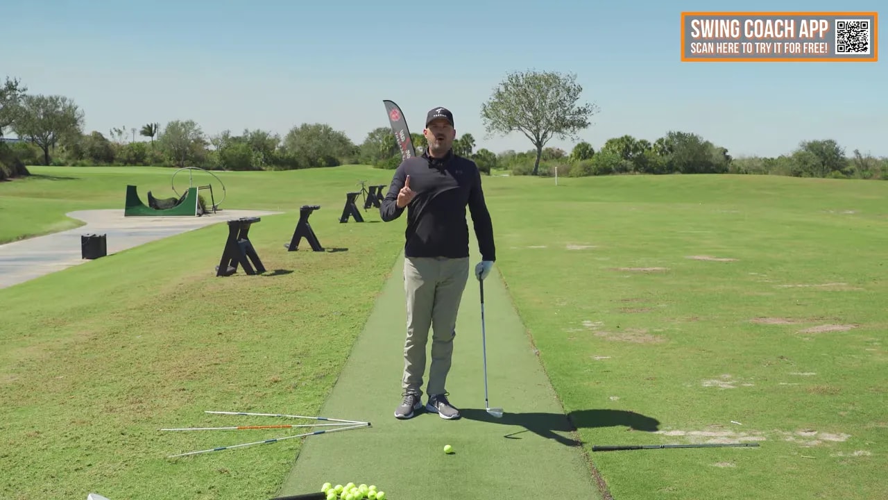 Practice area showing alignment sticks on the ground for golf drill checkpoints