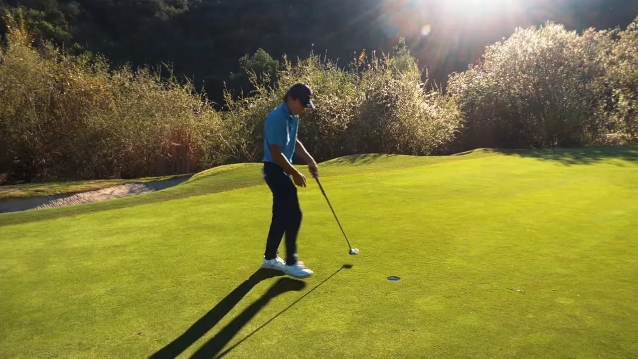Golfer putting on a green with the ball close to the hole, demonstrating speed control.