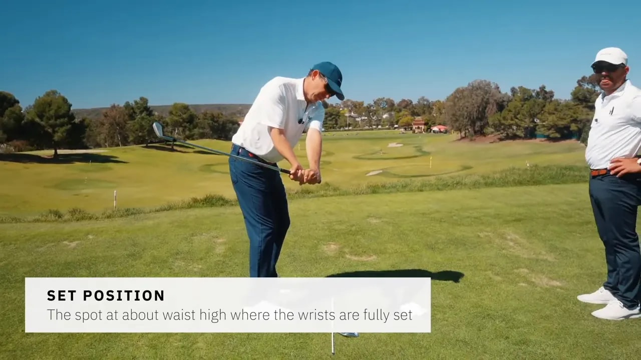 Golfer demonstrating the set position with wrists about waist high and on-screen text 'SET POSITION' explaining the spot