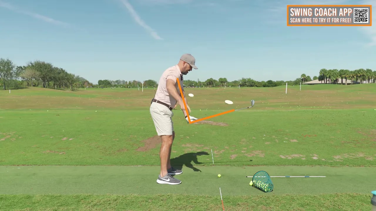 Side-on screenshot of a golfer mid-backswing with highlighted lines showing the wrist hinge and shaft angle, illustrating the 90-degree/45-degree hinge concepts.