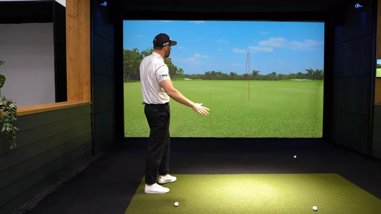 Golfer in simulator stance with hands extended, preparing for the 5 o’clock drill transition feel