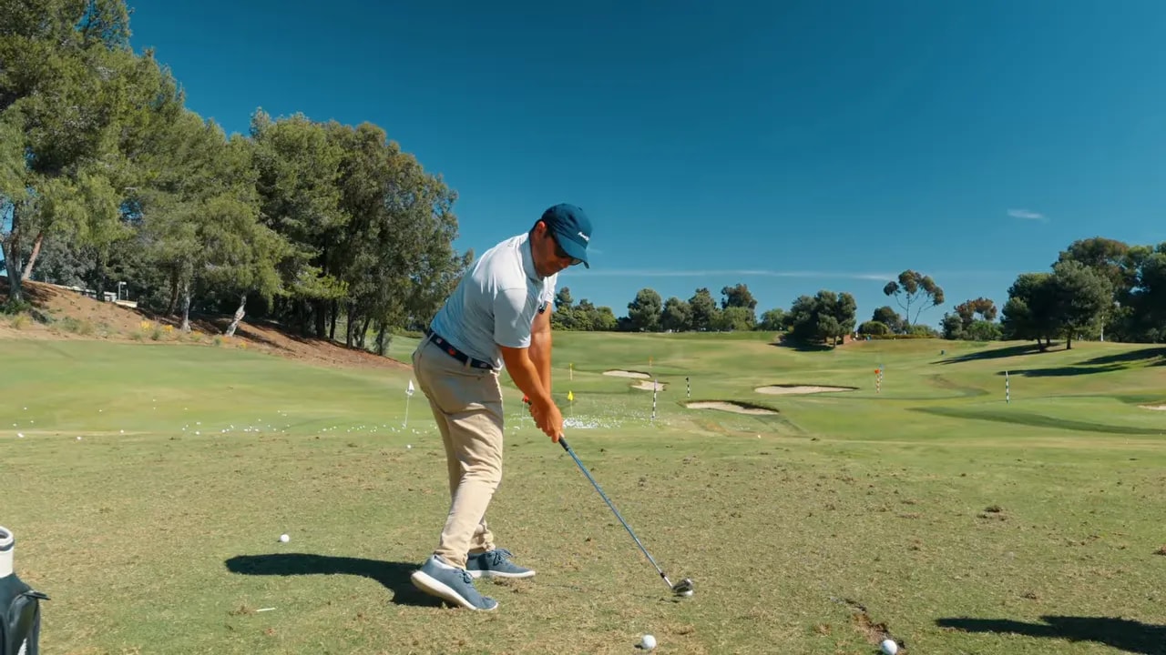 Golfer demonstrating downswing position while keeping the sternum oriented back longer to prevent spinning-out