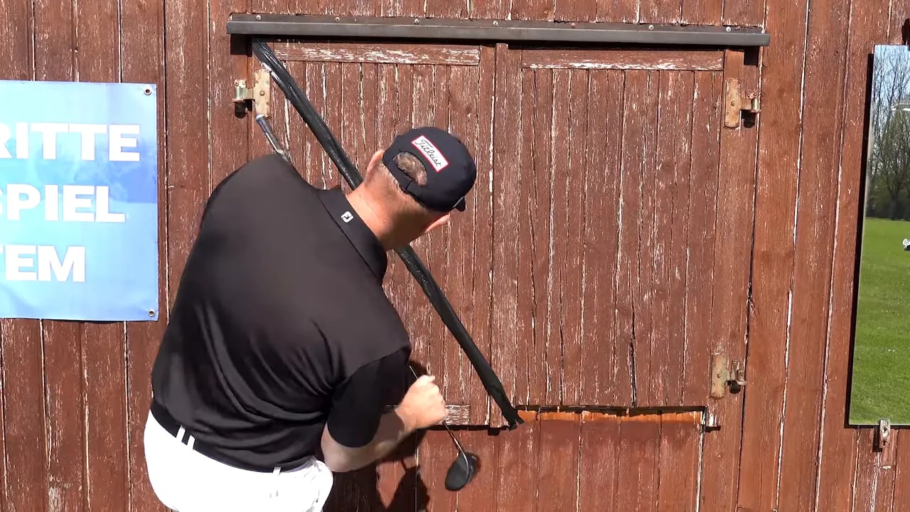 Golf coach demonstrating the arm drop to 45 degrees and smooth turning posture outdoors