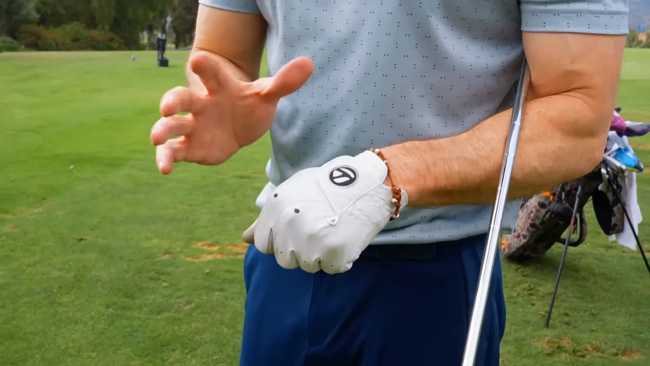 Close-up of a marked golf glove cue used to practice the knuckles-away feel for compression