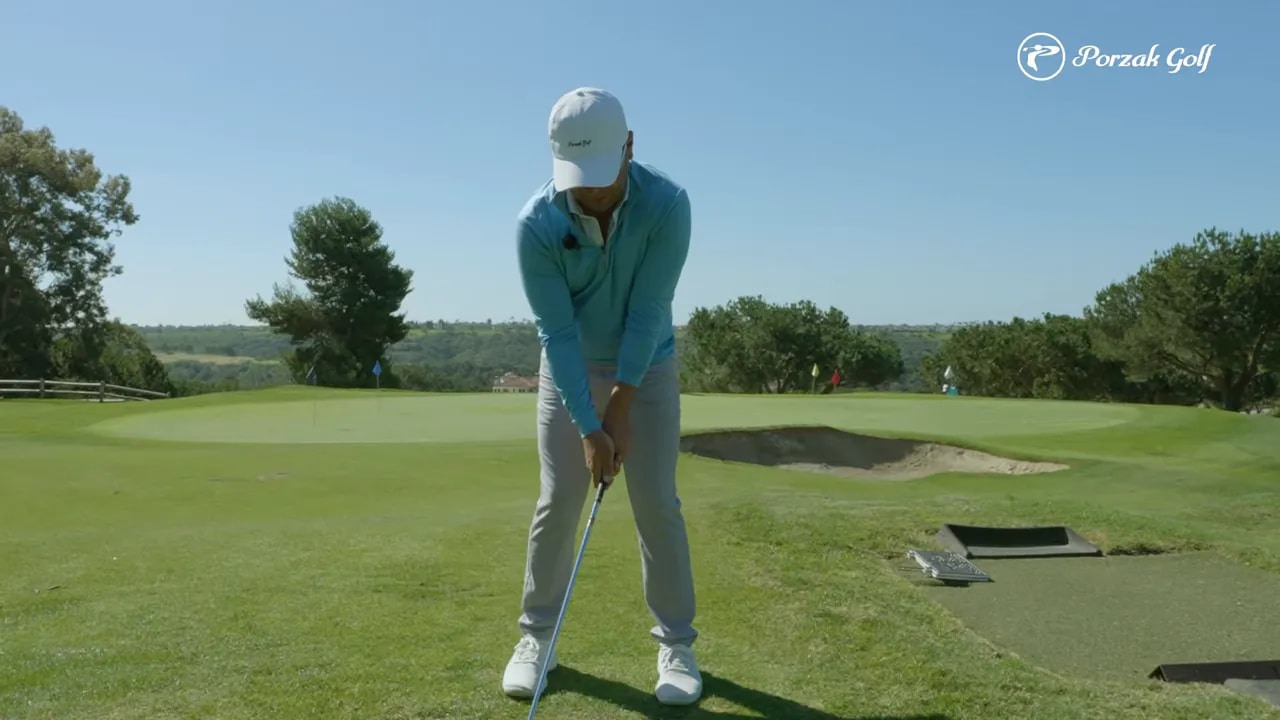 Golfer demonstrating a controlled sync position for golf compression drill