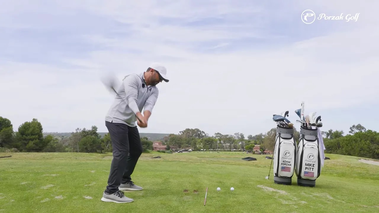 Golfer mid-swing demonstrating release transition on a golf driving range