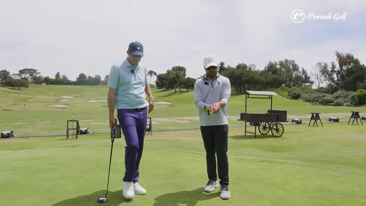Golf instructor showing a firm, controlled putting setup on the practice green