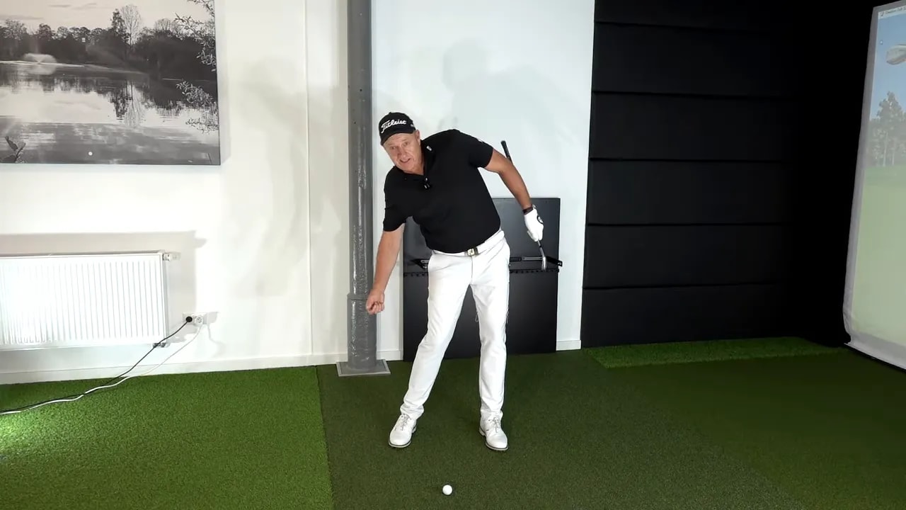 Golf coach demonstrating forward rib tilt and torso posture during the downswing
