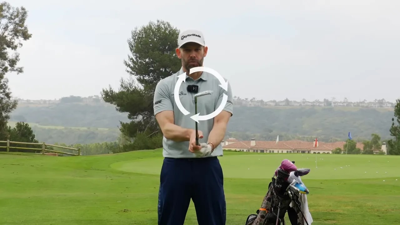 Golf instructor demonstrating clubface twist direction with a lead hand grip marker on the range