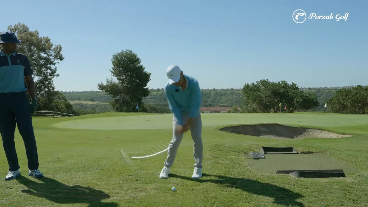 Golfer practicing compression on the downswing with a wedge on the fairway