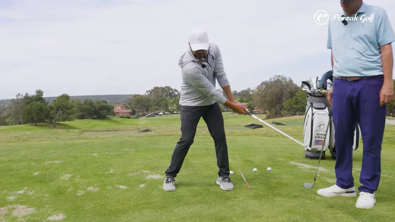 Golf instructor showing connected backswing with hands and chest moving together on the range