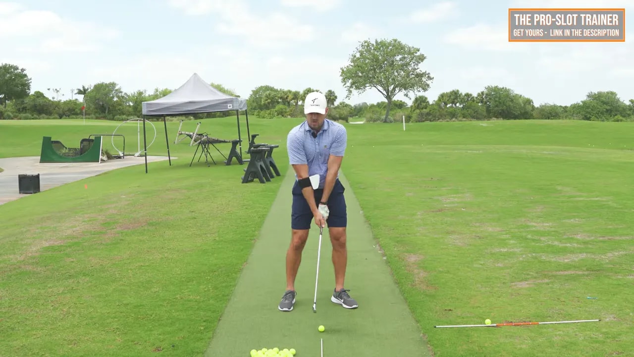 Golf drill setup showing right elbow position and trail arm width on the practice range