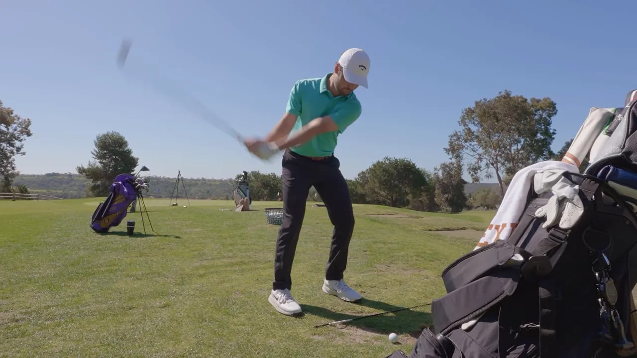 Golfer swinging with torso and arms staying connected on a golf practice range