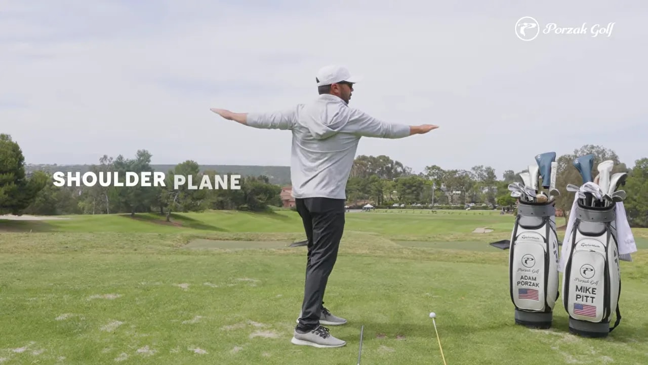 Golfer demonstrating shoulder plane with arms extended on the fairway