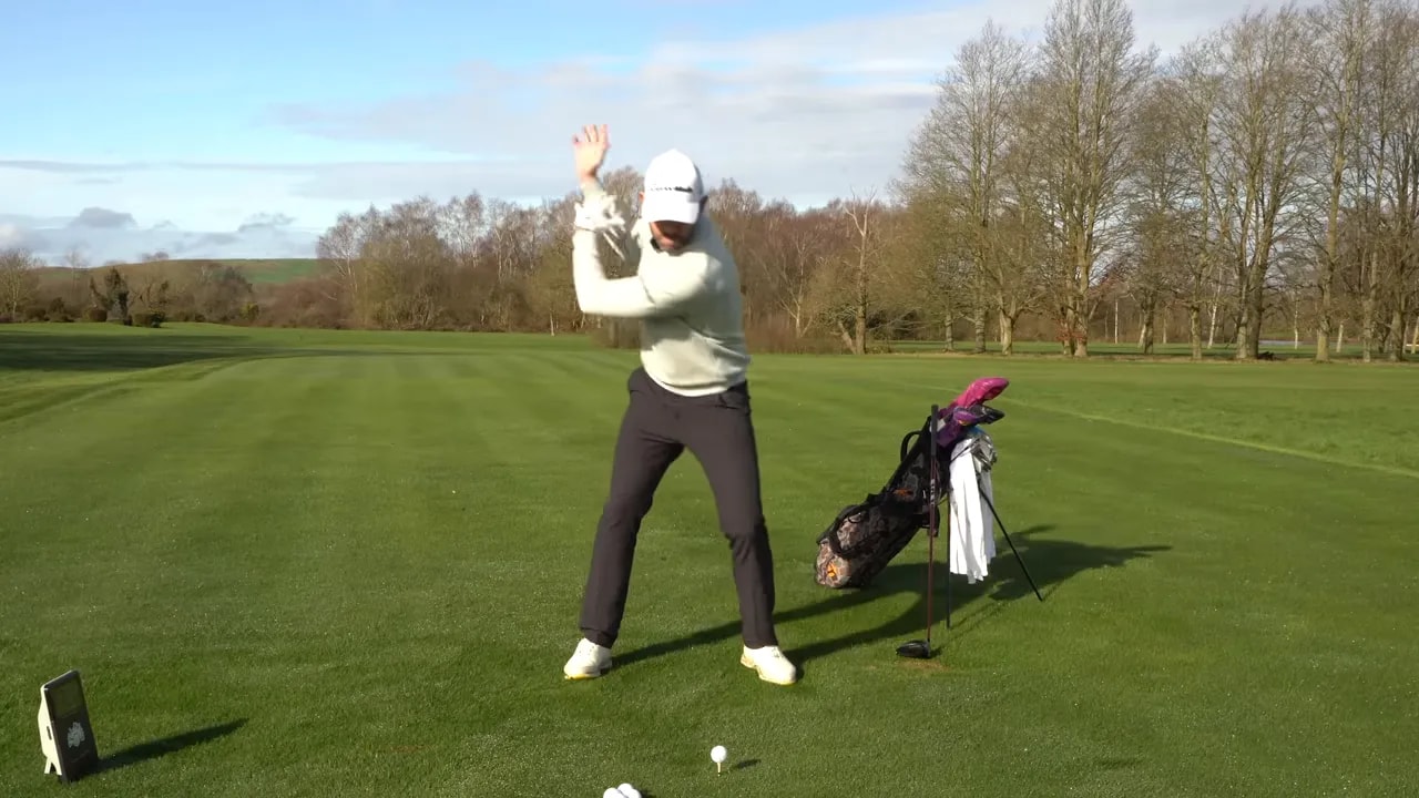 Golfer demonstrating push and left foot movement drill on the downswing at a golf range