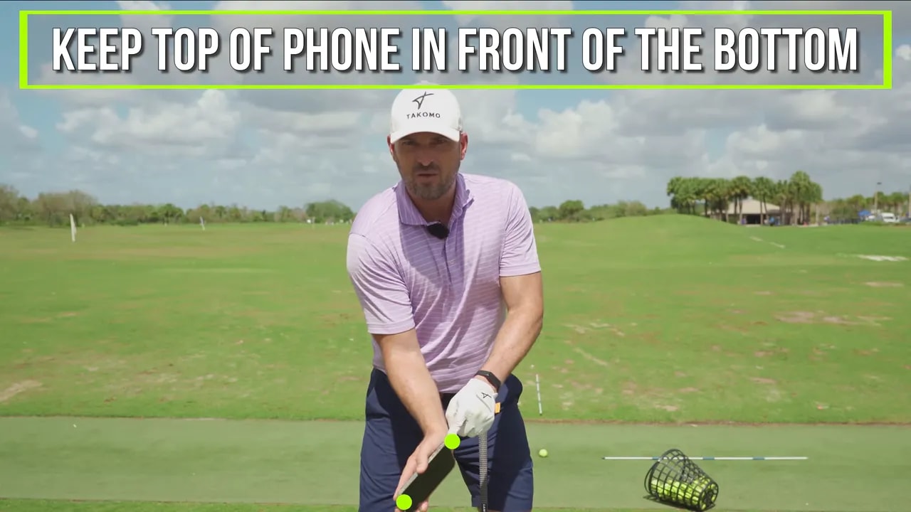 On-screen text cue reading keep top of phone in front of the bottom during wrist-forward through impact drill