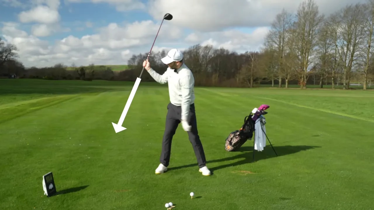 Golfer pointing the grip down toward the ground with a cue arrow during a short practice swing