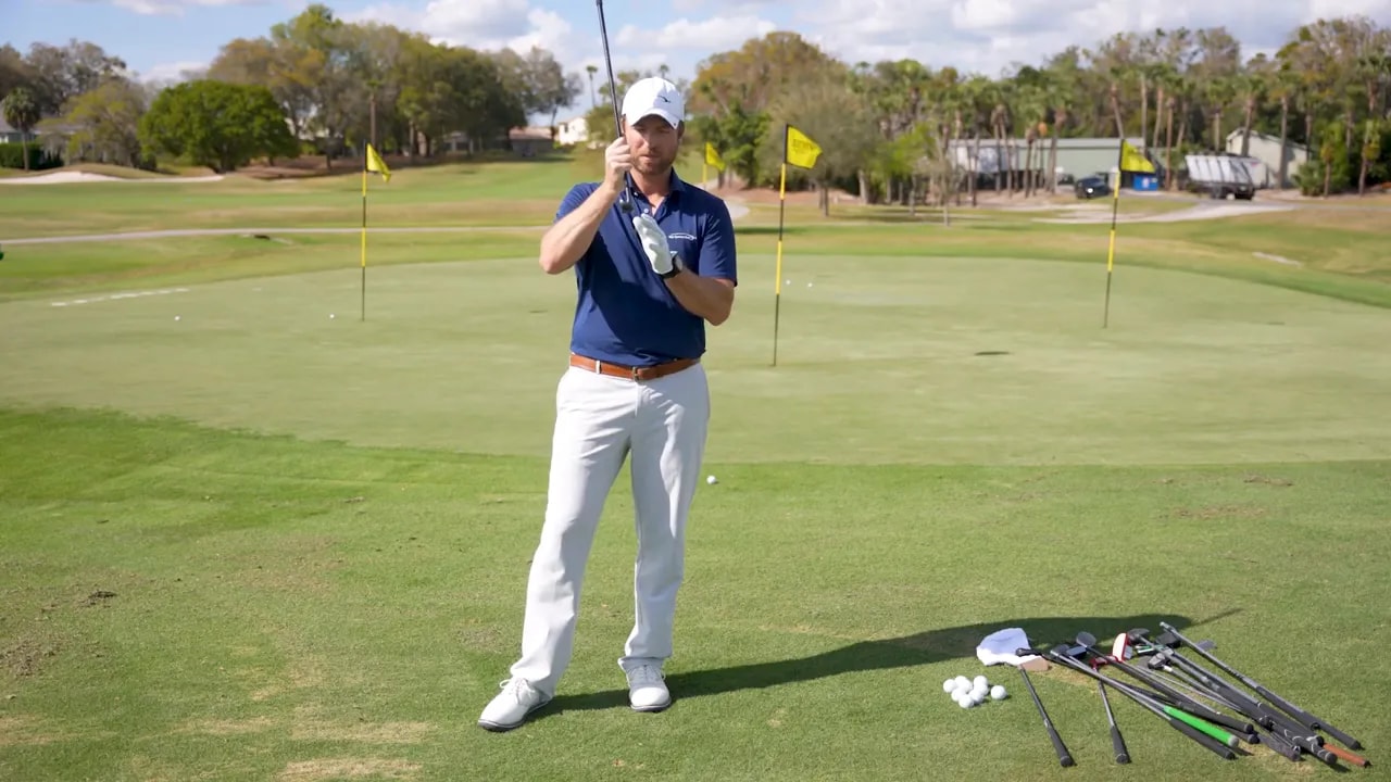 Golf instructor holding a chipper to illustrate rounded leading edge forgiveness