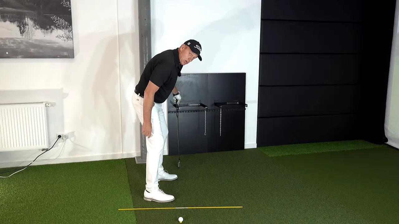 Golfer demonstrating the setup feel for a sequencing drill holding a club at address