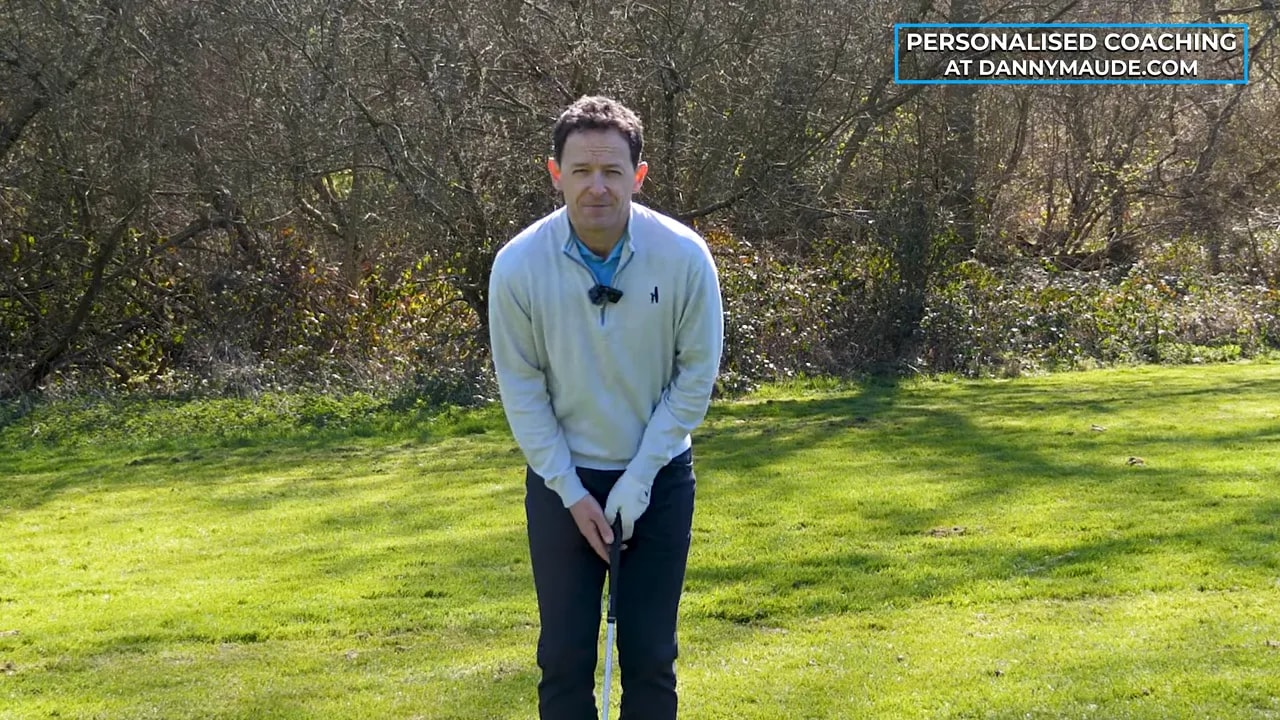 Front-on view of coach demonstrating Step 3 pitch shot setup for open-to-closed face
