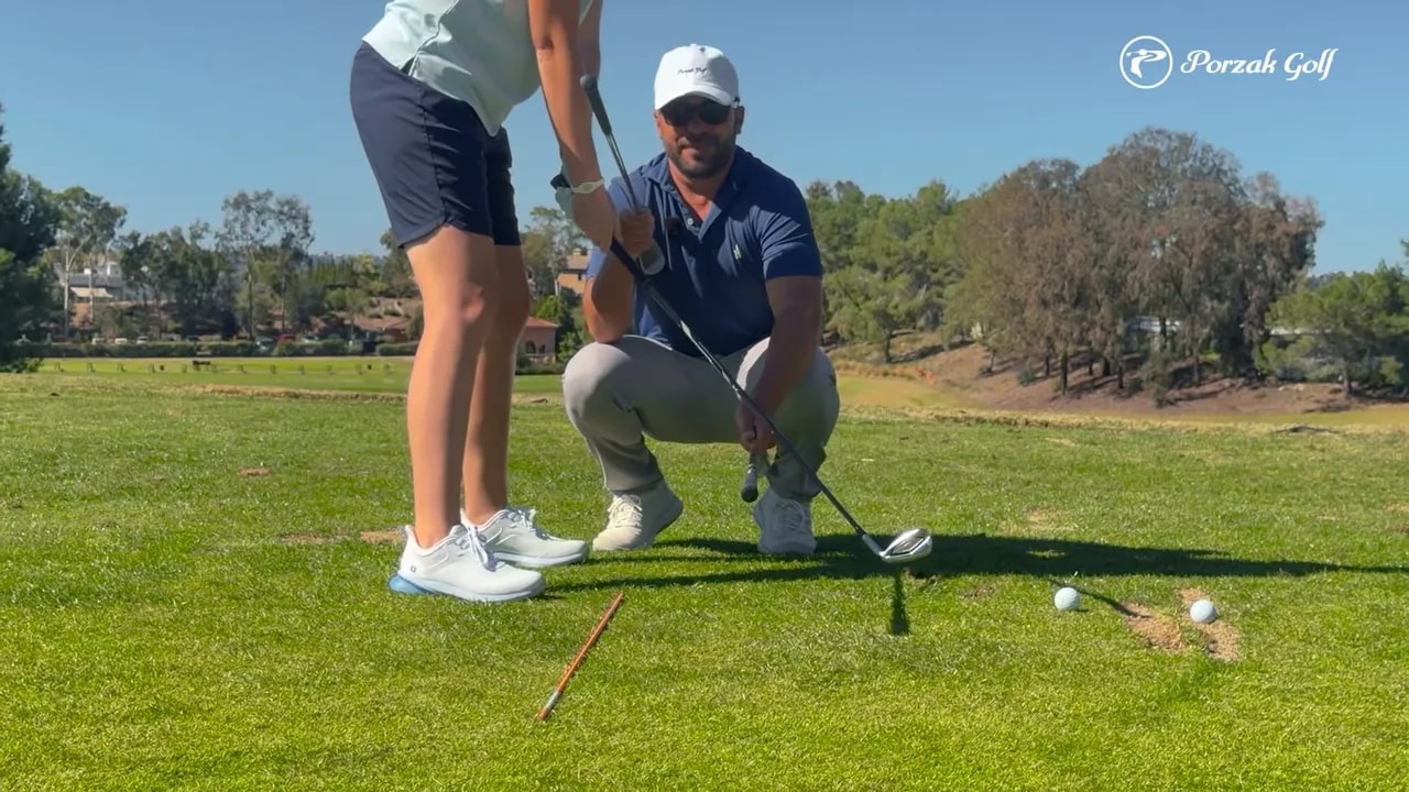 Close view of a coach demonstrating takeaway checkpoint for keeping hands inside the alignment line