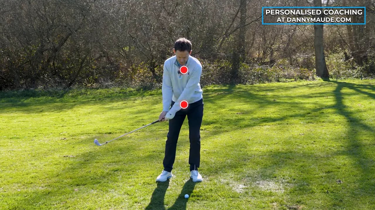 Coach demonstrating the tick-tock rhythm drill positions to control pitch shot depth and avoid digging