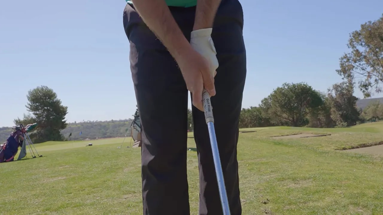 Close-up view of golfer’s trail hand and index finger position on the golf grip